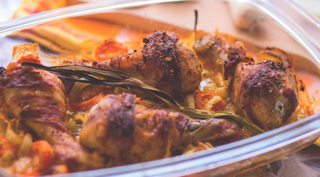 Bacon Wrapped Chicken Drumsticks baked in the oven in a glass dish